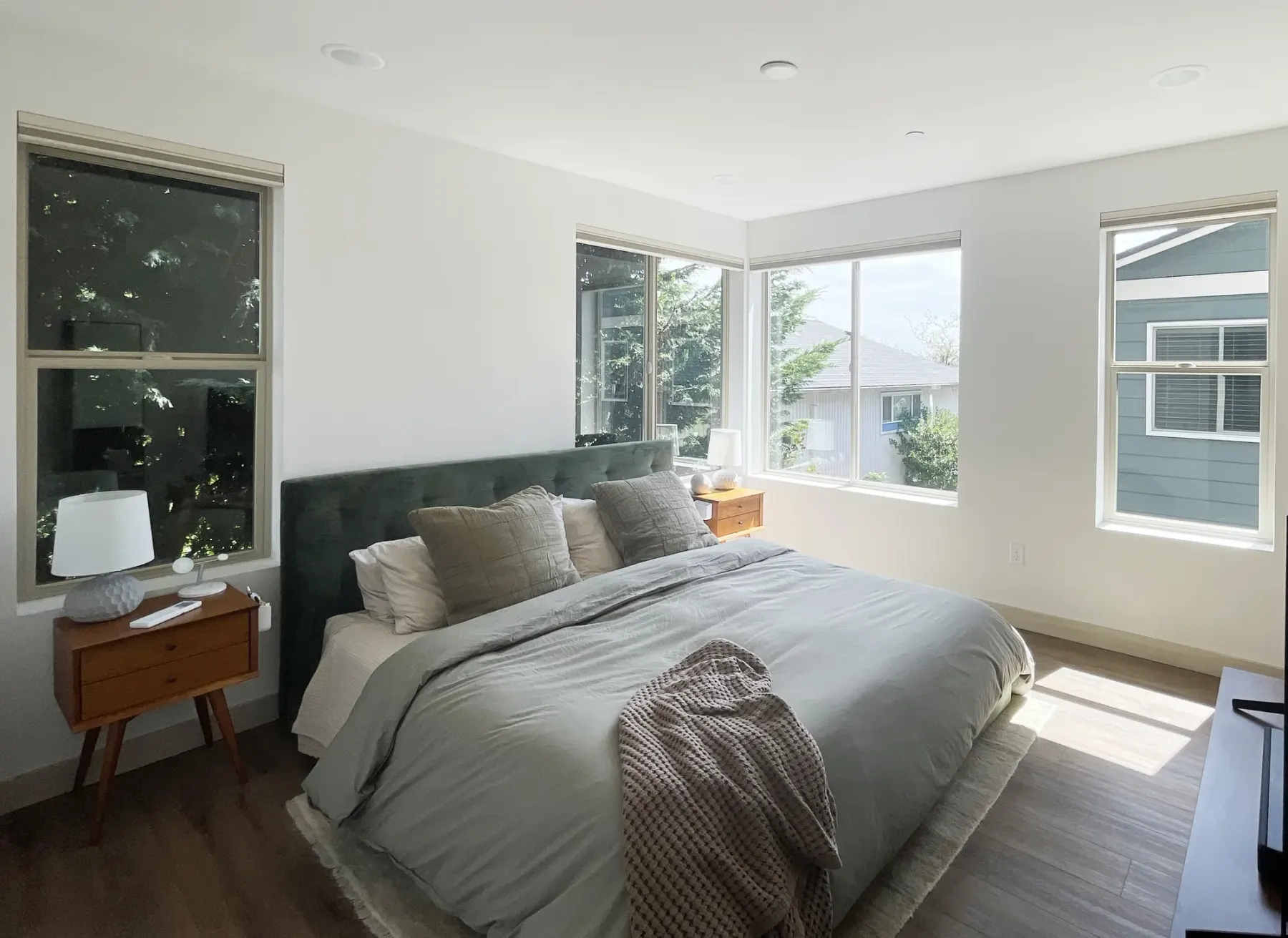 Motorized honeycomb shades raised above bedroom windows in a Seattle home