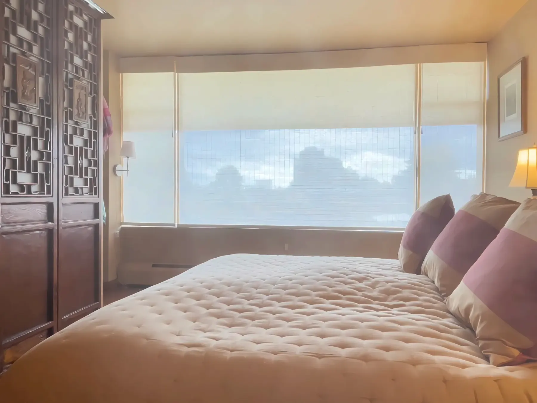 Dual-function shades with sheer woven shades in front and light-filtering roller shade behind in a Seattle bedroom
