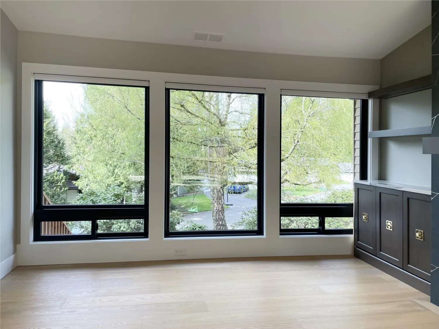 Raised motorized roller shades revealing the outdoor view from a remodeled Redmond living room