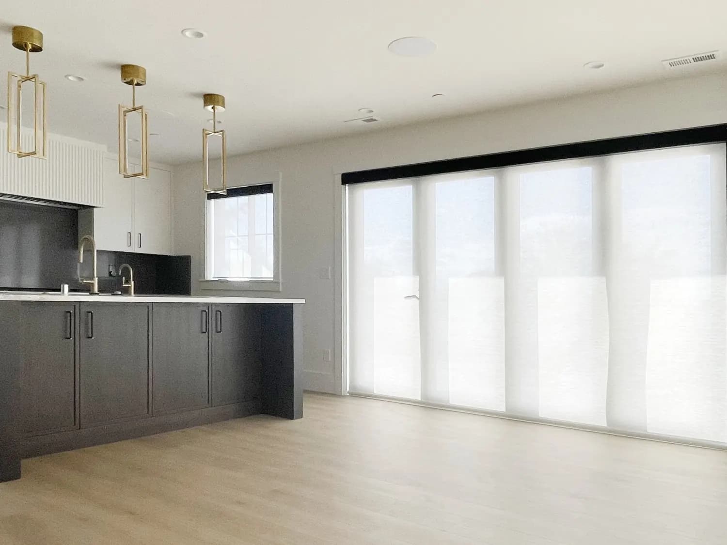 Motorized solar shades covering a sliding glass door in a Shoreline great room