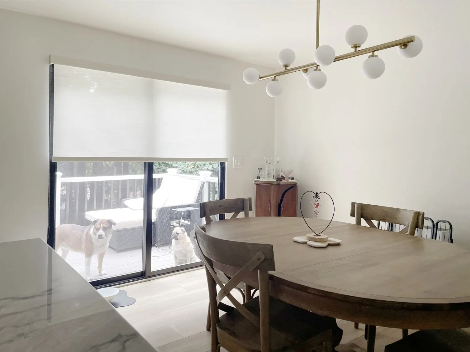 Roller shades covering a dining room sliding glass door in a Woodinville