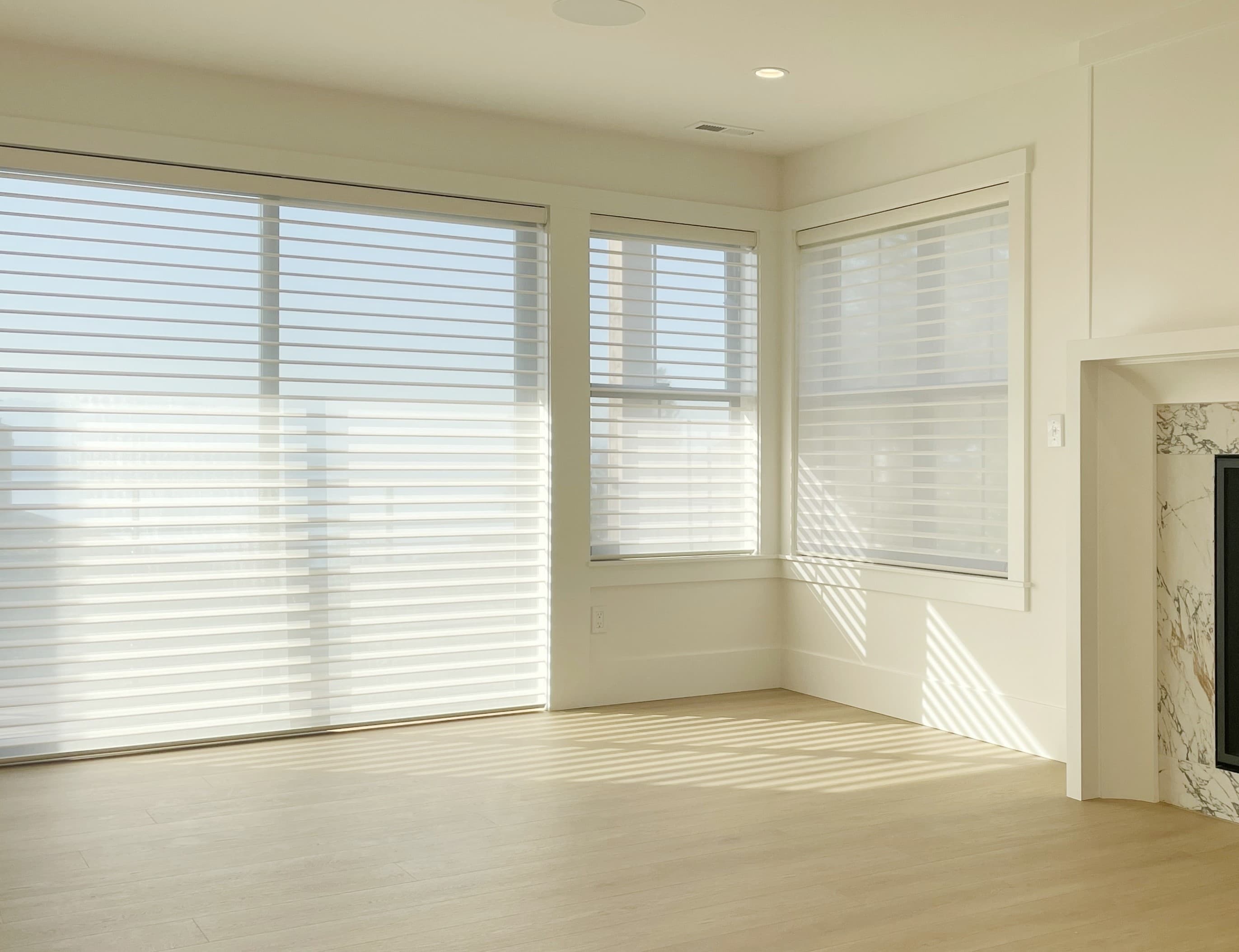 Motorized Hunter Douglas Silhouette® shades on a sliding glass door in a Shoreline living room